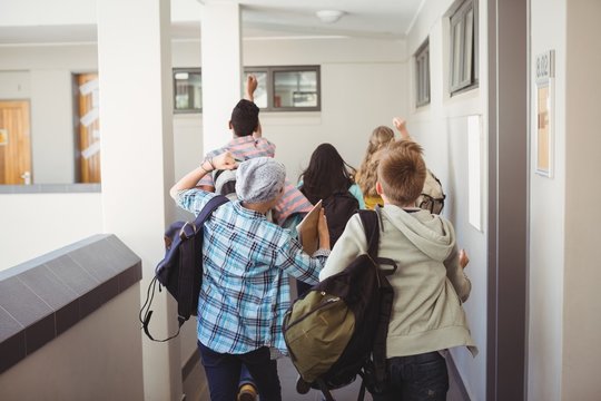 Group of classmate running in corridor 