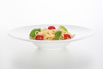 Fresh spaghetti with tomato and basil on white plate isolated