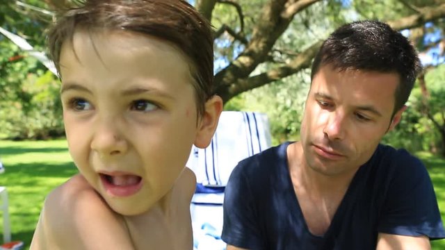 Father putting suncreen to his 6-8 year old child. Parent putting lotion to his kid