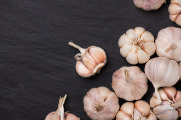 Garlic Cloves and Garlic Bulb on black stone table.