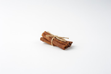 Bunch of cinnamon sticks bandaged by Twine on white background
