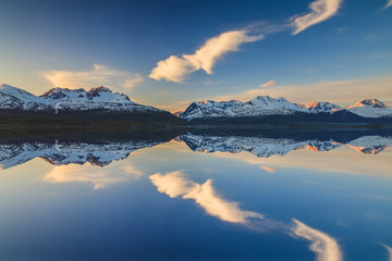 Reflection of of mountains in the Norwegian fjord at sunset