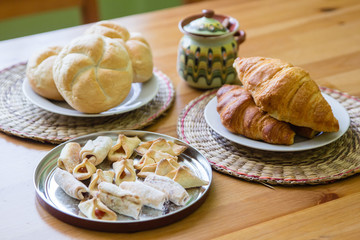 Croissant, buns and homemade cookies on wooden table background