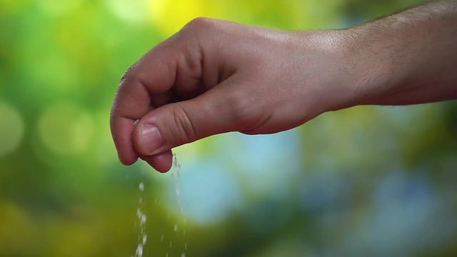 Close-up slow motion video of men's hand with salt on the kitchen