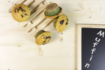 Muffin with chocolate drops on wood background - top view