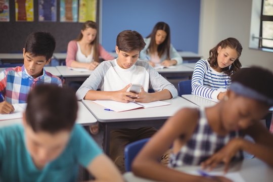 Student using mobile phone in classroom