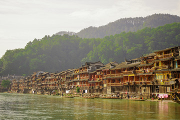 Fototapeta na wymiar Photo of Ancient City Fenix in China. Historic Asian Scenery with Water Canals, Wooden Houses, Gondola Boats