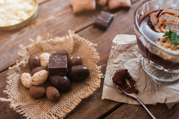 Chocolate and nuts with dessert closeup. Top view on rustic wooden table with sweets, variety of sugar treat. Confectionery, pastry, sweet tooth concept