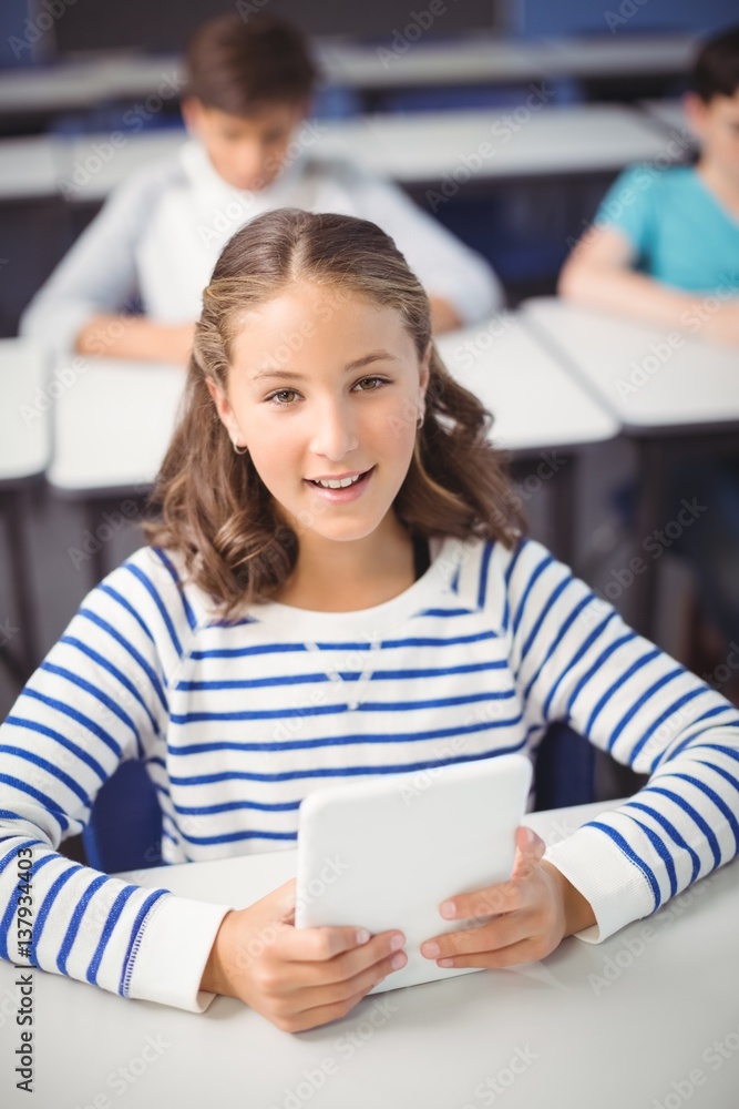 Wall mural student holding digital tablet in classroom