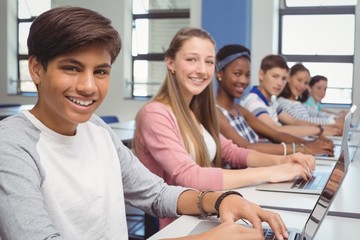 Students using laptop in classroom