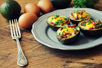 Avocado Egg Boats with bacon on wooden table