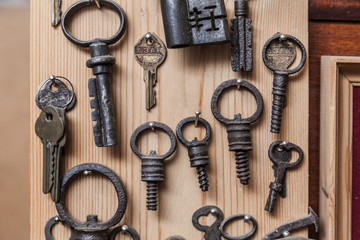 various old keys hanging on a wooden wall