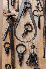 various old keys hanging on a wooden wall