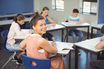 Schoolgirl sitting at desk in classroom