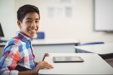 Schoolboy with digital tablet at desk