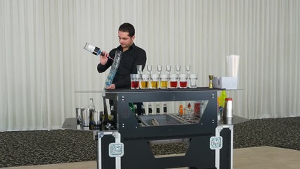 Bartending show with barman pouring multiple alcoholic cocktails shots at once