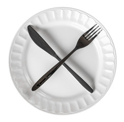Intermittent fasting cross symbol with knife and fork on plate isolated on white background, top view