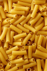 Dry uncooked rigatoni pasta background.