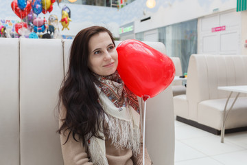 The girl holds a balloon in hand