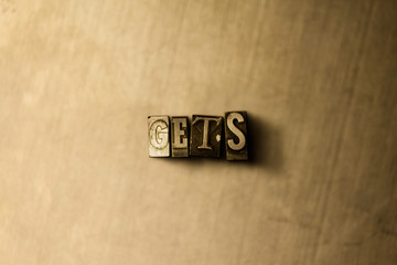 GETS - close-up of grungy vintage typeset word on metal backdrop. Royalty free stock illustration.  Can be used for online banner ads and direct mail.