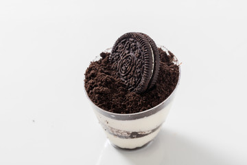 White mousse with oreo topping and an oreo biscuit