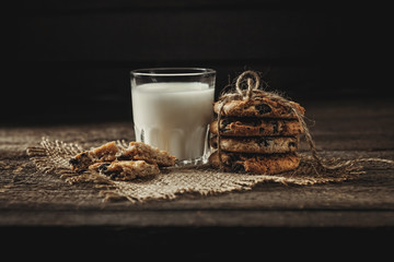 Milk beverages in glass bottles, crisp cookies with pomegranate seeds, vintage wooden background,...