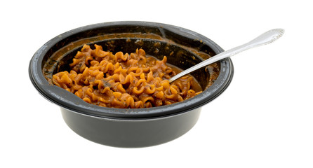 Marinara pasta in a plastic bowl with a fork in the food isolated on a white background.