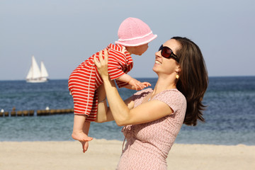 Eine junge Mutter mit ihrem Baby am Strand