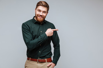 Smiling Bearded man in shirt pointing away