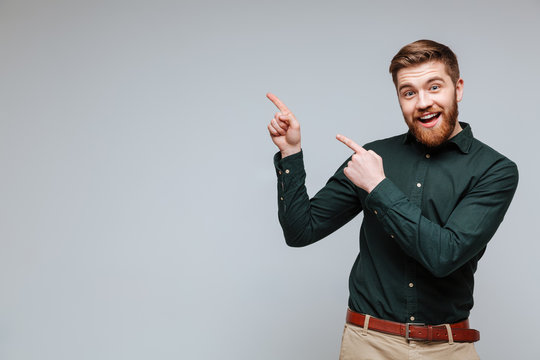 Happy Bearded man in shirt pointing up
