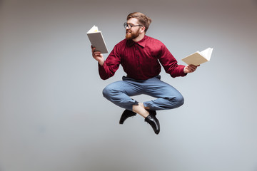 Male nerd jumping and reading in-flight