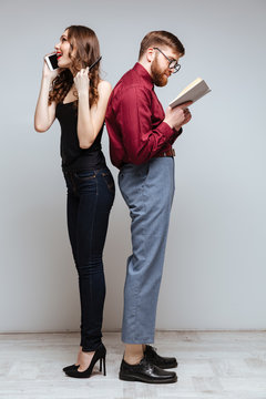 Woman and male nerd standing back each other