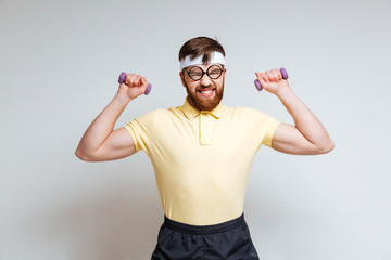Male nerd training with light dumbbells