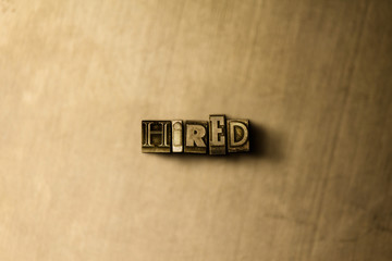 HIRED - close-up of grungy vintage typeset word on metal backdrop. Royalty free stock illustration.  Can be used for online banner ads and direct mail.