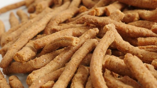 Slow pan on tasty integral breadsticks snacks fried in oil 4K 2160p 30fps UltraHD footage - Panning on grissini with chilli 