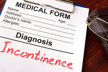 Medical form with diagnosis Incontinence on a table.