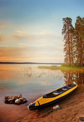  Kayak at lakeside at sunset. Karelia, Russia
