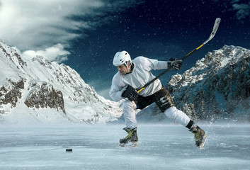 Ice hockey player in action outdoor around mountains