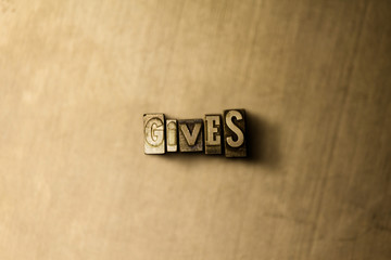 GIVES - close-up of grungy vintage typeset word on metal backdrop. Royalty free stock illustration.  Can be used for online banner ads and direct mail.