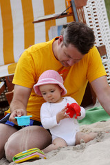 Ein junger Vater mit seiner Tochter am Strand