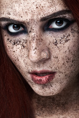 Naklejka premium Portrait of young girl with ginger hair and ground coffee on the face. Photo with art makeup. Mature woman making cosmetic mask. Face scrub. Beauty concept