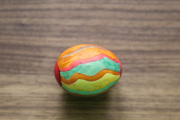 Buntes Osterei von Kind bemalt auf Nussbaum-Holztisch