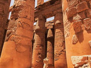 Ancient sculpture of the king (or Pharaoh) headless, located among the columns