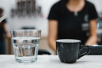 cup with coffee near a glass of water