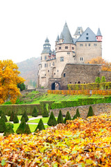 Autumn Burresheim Castle with topiary green trees in ornamental garden