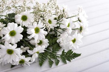Bouquet from white flowers on white wooden table