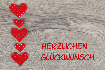 Herzen auf Holzhintergrund: Herzlichen Glückwunsch!