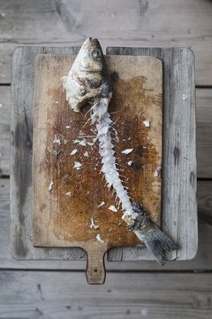 A branzini carcass on a chopping board