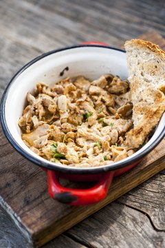 Chanterelle mushrooms with sour cream in a red enamel pan