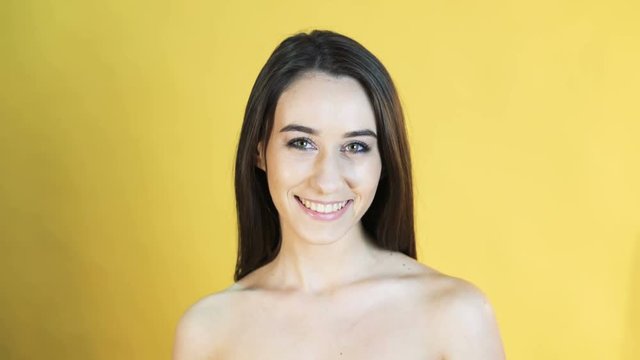 Portrait of smiling girl on yellow background in 4K